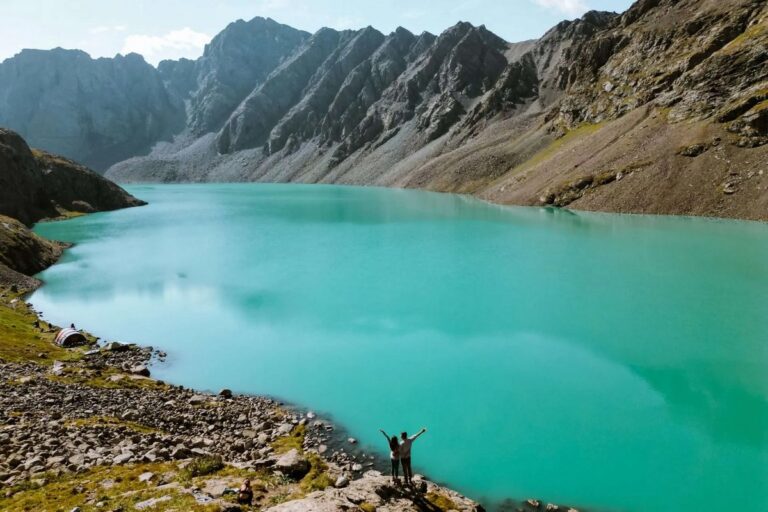 Солнечное озеро Ала-Кёль в окружении скалистых гор